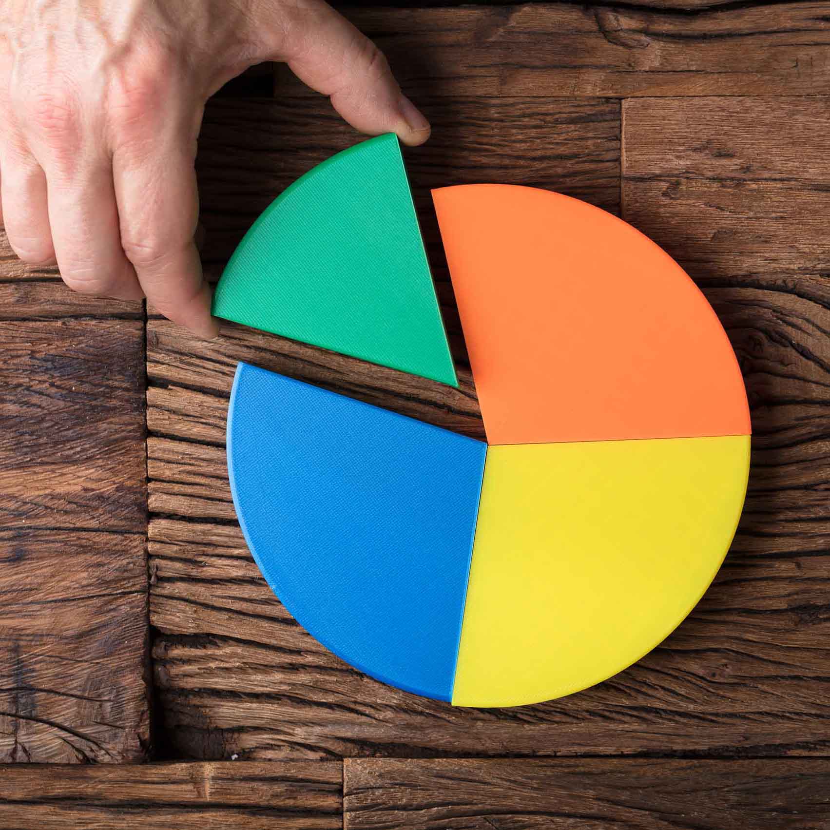 Businessperson Placing A Last Piece Into Pie Chart High Angle View Of Businessperson's Hand Placing A Last Piece Into Pie Chart